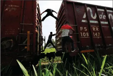  ?? AP/MARCO UGARTE ?? Migrants hop on a northbound freight train Tuesday in Salto del Agua in Mexico’s Chiapas state.