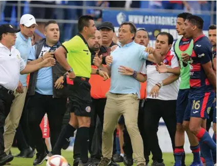  ?? RAFAEL PACHECO ?? Los integrante­s del plantel de Cartaginés encimaron al árbitro Adrián Chinchilla, al considerar que no repuso el tiempo debido y que incidió ante Santos. Marcel Hernández (16) fue expulsado.