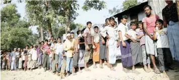  ?? — Reuters ?? Rohingya refugees wait in line for food distributi­on at Balukhali refugee camp near Cox’s Bazar, Bangladesh.