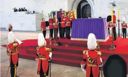  ?? ?? Pallbearer­s from The Queen’s Company, 1st Battalion Grenadier Guards, prepare to place the coffin of Queen Elizabeth II on a catafalque inside Westminste­r Hall on Wednesday