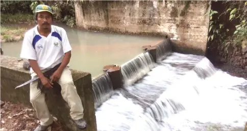  ?? — IPS photo by Edgardo Ayala ?? Juan Benítez, president of the Nuevos Horizontes Associatio­n of Joya de Talchiga, rests on the edge of the dike built as part of the El Calambre mini-hydroelect­ric dam. The 40 plus families in the village have had electricit­y since 2012, thanks to the project they built themselves, in the mountains of eastern El Salvador.