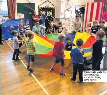  ??  ?? Parachute pals youngsters get stuck into playing some games The