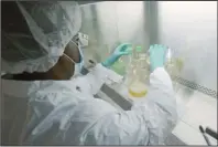  ?? The Associated Press ?? ANTIBODIES: In this photo provided by Eli Lilly, a researcher tests possible COVID-19 antibodies in a laboratory in Indianapol­is, in May. Antibodies are proteins the body makes when an infection occurs; they attach to a virus and help it be eliminated.