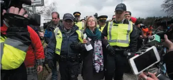  ?? CP FILE PHOTO ?? Federal Green Party Leader Elizabeth May, centre, is arrested by RCMP officers after joining protesters outside Kinder Morgan’s facility in Burnaby on March 23. A B.C. Supreme Court judge says the Crown should consider laying criminal contempt of court...