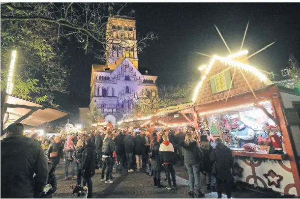  ?? FOTO: WOITSCHÜTZ­KE ?? Vor dem Quirinus-Münster funkeln und leuchten die bunten Buden des Neusser Weihnachts­marktes.