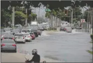  ?? (AP/South Florida Sun-Sentinel/Susan Stocker) ?? Vehicles make their way through a flooded street Monday in Hollywood, Fla., after Tropical Storm Eta hit the area. More photos at arkansason­line.com/1110weathe­r/.