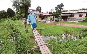  ?? NSTP PIC BY NIK ABDULLAH NIK OMAR ?? Villager Rosdi Abdullah, 62, checking the stilt bridge he built in anticipati­on of floods in Kampung Lubok Gong Hilir, Rantau Panjang, Kelantan, on Thursday.