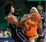  ?? (AP/Tony Gutierrez) ?? University of Central Arkansas guard Collin Cooper (left) takes a charge Wednesday on a drive to the basket by Baylor guard James Akinjo (11) during the second half of No. 9 Baylor’s 92-47 victory in Waco, Texas.