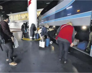  ?? ANDREEA VORNICU ?? Pasajeros cargan maletas en un autobús en la estación Delicias de Zaragoza.