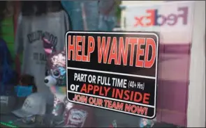  ??  ?? A sign for workers hangs in the window of a shop along Main Street in Deadwood, S.D. The US workingage population shrank last year for the first time on record.