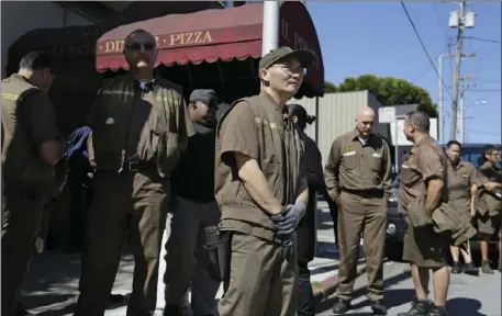  ?? AP PHOTO/ERIC RISBERG ?? UPS workers gather outside a UPS package delivery warehouse where a shooting took place Wednesday in San Francisco. A UPS spokesman says four people were injured in the shooting at the facility and that the shooter was an employee.