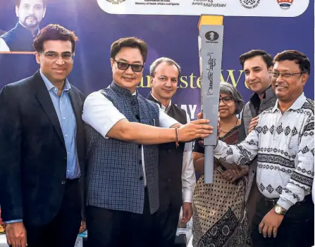  ?? PTI ?? Getting ready:
Union Law Minister Kiren Rijiju hands over the torch to Indian chess Grandmaste­r Dibyendu Barua at the torch relay for the 44th Chess Olympiad, at Red Fort in New Delhi. GM Viswanatha­n Anand and FIDE President Arkady Dvorkovich are also seen.