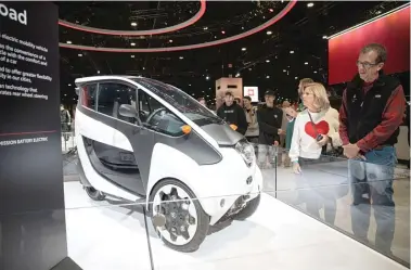  ?? ANTHONY VAZQUEZ/SUN-TIMES ?? Attendees check out a prototype of the personal electric vehicle I-Road on Sunday, Feb. 12, at the Chicago Auto Show at McCormick Place.