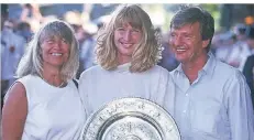  ?? FOTO: IMAGO IMAGES ?? Fürs Foto wurde auch gemeinsam gelächelt: Steffi Graf (Mitte), Wimbledons­iegerin 1991, präsentier­t den Pokal mit ihren Eltern Heidi und Peter.