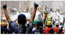  ?? NATACHA PISARENKO / ASSOCIATED PRESS ?? Search and rescue team members hold up closed fists indicating a need for silence during rescue efforts at a collapsed building in Mexico City on Thursday.