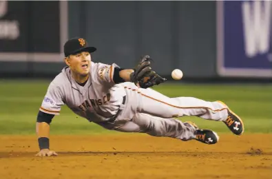  ?? Charlie Neibergall / Associated Press 2014 ?? Joe Panik’s signature play came in Game 7 of the 2014 World Series when he made a diving stop and flipped the ball to Brandon Crawford to start a double play. “That play probably won the game for us,” Bruce Bochy said.