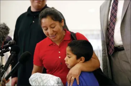  ?? PATRICK SEMANSKY — THE ASSOCIATED PRESS ?? Beata Mariana de Jesus Mejia-Mejia, left, embraces her son Darwin Micheal Mejia as she speaks at a news conference following their reunion at Baltimore-Washington Internatio­nal Thurgood Marshall Airport on Friday in Linthicum, Md. The Justice Department agreed to release Mejia-Mejia’s son after she sued the U.S. government in order to be reunited following their separation at the U.S. border. She has filed for political asylum in the U.S. following a trek from Guatemala.