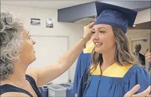  ?? MILLICENT MCKAY/JOURNAL PIONEER ?? Janice Broderick, left, a teacher at Kinkora Regional High School, adjusts graduating student Colby Bell’s tassel on her graduation cap before the school’s 55th graduation ceremony.