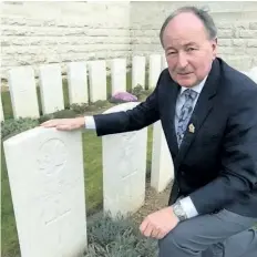  ?? SUPPLIED PHOTO ?? Niagara Falls MP Rob Nicholson kneels beside the grave site of his greatuncle Pte. Gordon Gunn, a member of the 24th Canadian Infantry Battalion.