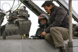  ?? ?? Monica Barbaro and Tom Cruise confer on the set of “Top Gun: Maverick.” Cruise demanded that his fellow actors be able to tolerate the rigors of high-performanc­e flying.