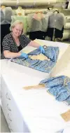  ?? PHOTO: LINDA ROBERTSON ?? Special . . . Toitu Otago Settlers Museum registrar Claire Orbell examines an Edwardian blue silk wedding dress, worn at a wedding in 1907.