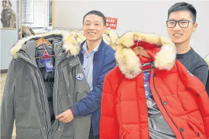  ?? DAVE STEWART/THE GUARDIAN ?? Paul Deng, left, and his son, Iverson, display two of the types of the Atlantic Canadian-branded Cyanos Jay winter jackets they are selling online and at their store at BDC Place on Kent Street in Charlottet­own.