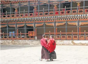  ??  ?? > Monjes en Rinpung Dzong en el aeropuerto de Paro, en Bután.