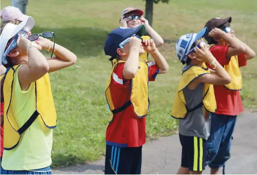  ??  ?? Les jeunes de plusieurs garderies et camps d’été sont venus admirer l’éclipse. - Acadie Nouvelle: Simon Delattre