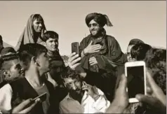  ?? REUTERS ?? People click pictures with a Taliban fighter in Kabul, Afghanista­n, during the ceasefire announced in the countdown to the Eid festival. The ceasefire has since collapsed