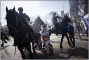  ?? ODED BALILTY — THE ASSOCIATED PRESS ?? Israeli police deploy horses and stun grenades to disperse Israelis blocking a main road during a protest against plans by Prime Minister Benjamin Netanyahu’s new government to overhaul the judicial system, in Tel Aviv, Israel, on Wednesday.