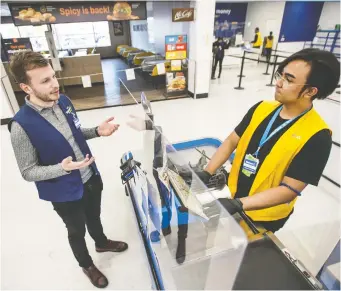  ?? PETER J. THOMPSON ?? Michael Gill, left, Walmart Canada Senior Manager Store Innovation, chats with employee Benjie Cayabyabat at the company’s Stockyards Toronto location where social distancing and plastic dividers have been implemente­d. Gill, 27, has been with the company since he was a teenager.