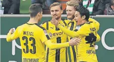  ?? FOTO: DPA ?? So sehen Sieger aus: Die Dortmunder Julian Weigl, Marcel Schmelzer, André Schürrle und Shinji Kagawa (v.l.) feiern in Bremen.