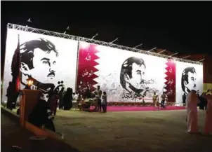  ?? KARIM JAAFAR/AFP ?? Qataris write comments on a wall bearing a portrait of Qatar’s Emir, Sheikh Tamim bin Hamad Al Thani, which has become the symbol of Qatari resistance during the monthlong row between Doha and neighbouri­ng countries, in Doha, on July 6.