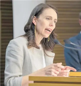  ??  ?? Prime Minister Jacinda Ardern announces the alert level decision at Parliament yesterday. Right: Heavy traffic on St Lukes Rd, Mt Albert, yesterday on the way to the White Cross Covid-19 testing station.