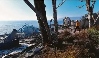  ?? Frederic J. Brown / AFP / Getty Images ?? A firefighte­r inspects what is left of a beachside luxury home along the Pacific Coast Highway community of Point Dume in Malibu on Sunday. The Woolsey Fire could threaten Santa Monica.