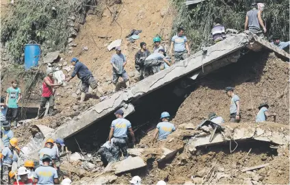  ?? Picture:EPA-EFE ?? GRIM TASK. People work during rescue operations for landslide victims caused by typhoon Mangkhut in Ucab village, Itogon town, Benguet Province, Philippine­s, yesterday.