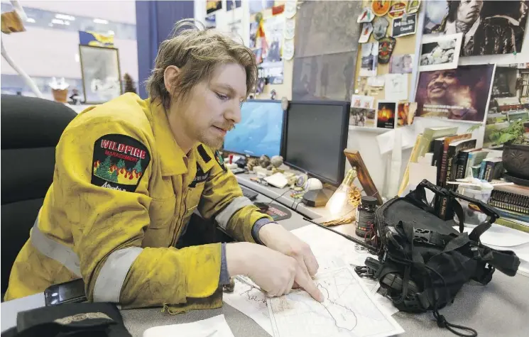  ?? TOP PHOTO: IAN KUCERAK PHOTO BELOW: KENT JENNINGS ?? A year later, Kent Jennings speaks about fighting the 2016 Fort McMurray wildfires in his Fort McMurray office. Below is a dramatic photo Jennings snapped of Fire 9 from the boreal forest floor outside Fort McMurray on May 2, 2016, shortly before the...