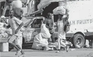  ?? CLARENS SIFFROY/AFP AFP/Getty Images/TNS ?? People run after reportedly hearing gunshots in Port-au-Price, Haiti, on Saturday. Amid the gang violence that has upended Haitian society, journalist­s say they face particular dangers in simply trying to provide news of the events.