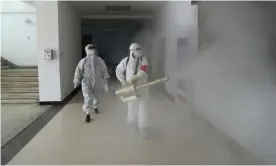  ??  ?? Volunteers in protective suits disinfect a residentia­l compound in Wuhan on Sunday. Photograph: China Daily/Reuters