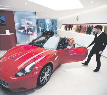  ?? Bloomberg Picture: ?? R3 MILLION. An employee examines a Ferrari California sports car in the showroom.