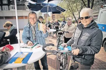  ??  ?? Uwe Kohfeldt (links) vom Kommissari­at für Kriminalpr­ävention und Opferschut­z der Kreispoliz­ei codierte mit seinen Kollegen rund 100 Fahrräder in Monheim. Die Plaketten sollen abschrecke­nd auf Diebe wirken.
