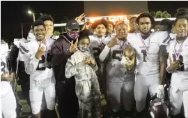 ?? BILL DALEY For the Miami Herald ?? Norland’s Tayari Sherwood (1) holds the Tri-County 6A-1A silver trophy after the Vikings’ 41-28 victory over Coconut Creek on Friday at Traz Powell Stadium.