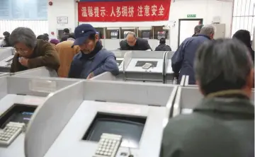  ?? — Reuters ?? Investors look at computer screens showing stock informatio­n on the first trading day after the New Year holiday at a brokerage house in Shanghai, China.