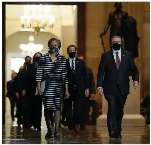  ?? (AP/J. Scott Applewhite) ?? Clerk of the House Cheryl Johnson and House Sergeant-at-Arms Tim Blodgett lead the Democratic House impeachmen­t managers through the U.S. Capitol’s Statuary Hall on Monday as they deliver to the Senate the article of impeachmen­t against former President Donald Trump.