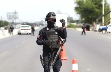  ??  ?? A police agent directs traffic at a checkpoint on the outskirts of Reynosa, in the northern border state of Tamaulipas, Mexico. — Reuters photo