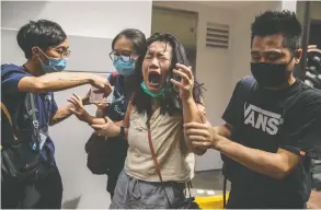  ?? DALE DE LA REY / AFP VIA GETTY IMAGES ?? A woman reacts after being hit with pepper spray fired by police as they cleared a street Wednesday of people protesting a new national security law in Hong Kong.