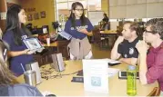  ?? Deer Park ISD ?? Deepwater Junior High seventh-graders Alexis Hernandez, left, and Delysa Romero discuss the Explain Everything app to Deer Park Independen­t School District secondary teachers during a recent technology training.