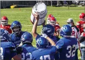  ?? JOSE QUEZADA, HUMEDIA — FOR THE TIMES-STANDARD ?? A victorious Husky football squad hoists their trophy high at the end of the Milk Can game last Saturday, the winning symbol of the longtime Eel River Valley rivalry between the Fortuna High Huskies and the Ferndale High Wildcats.