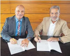  ?? FOTO: WOLFGANG LUTZ ?? Bürgermeis­ter Jürgen Köhler (links) und Martin John, Regio-Manager der Telekom, unterzeich­nen eine Absichtser­klärung für eine weitere gemeinsame Zusammenar­beit.