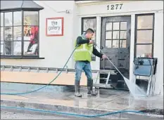  ?? Michael Owen Baker For The Times ?? ERIC JUAREZ washes the sidewalk Jan. 14. Montecito may still be at risk, especially if it rains heavily before storm drains are unclogged.